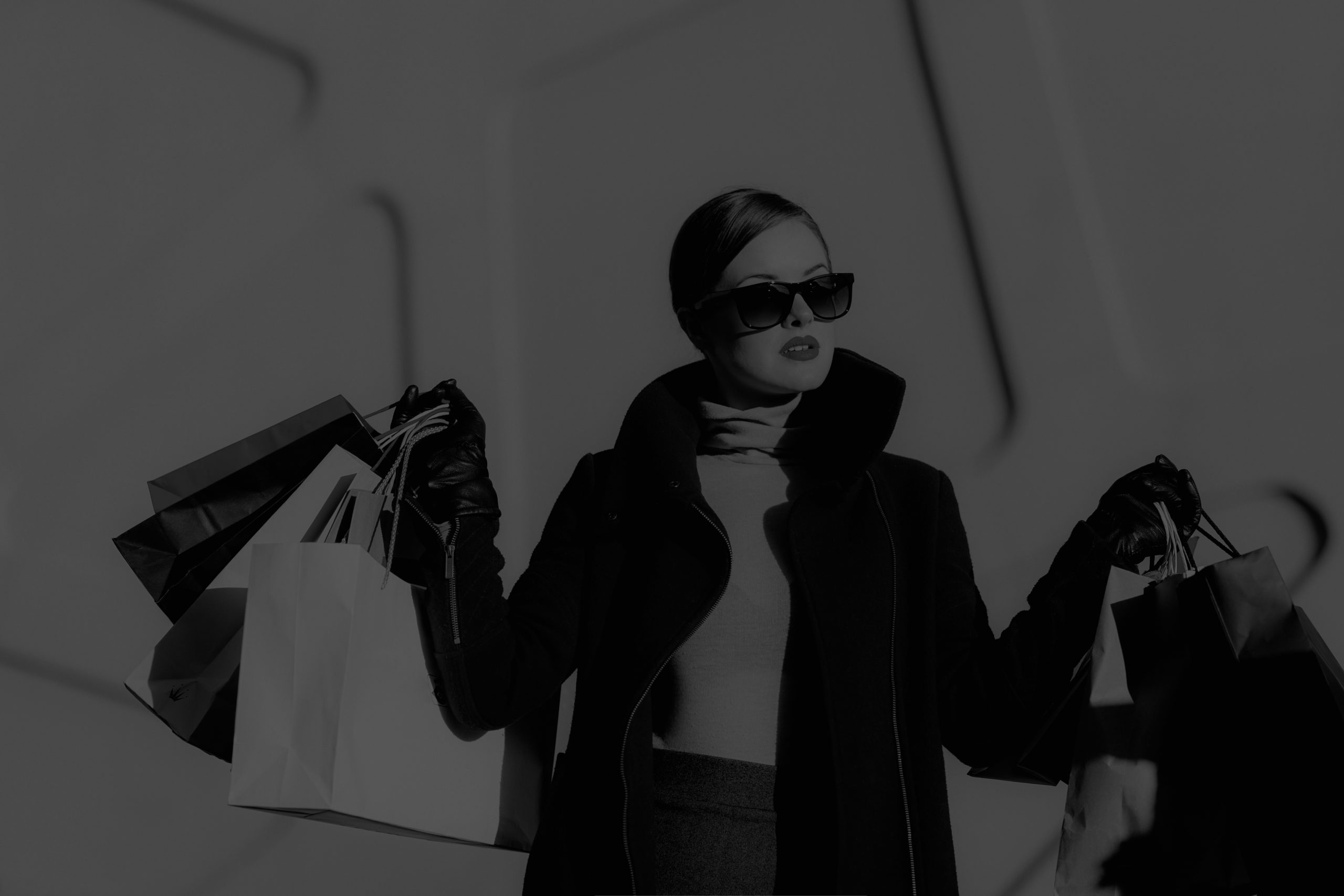 Black-and-white image of a shopper carrying multiple shopping bags, representing the modern AI-powered buyer journey from product discovery and evaluation to purchase decisions and post-purchase support in Generative Engine Optimization (GEO).