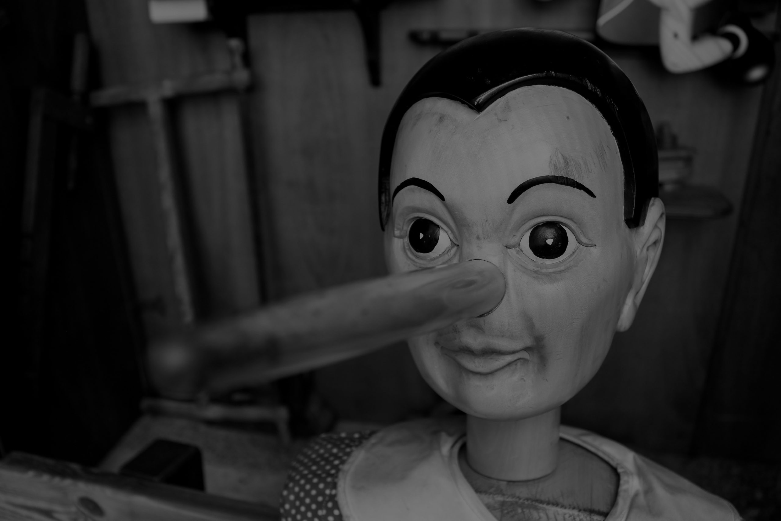 Black-and-white image of Pinocchio with an exaggerated long wooden nose, symbolizing misinformation and myths about Generative Engine Optimization (GEO). The image illustrates a blog analyzing 15,900 AI-generated answers across five large language models, challenging common assumptions about AI citations, owned media, content freshness, and listicle performance.