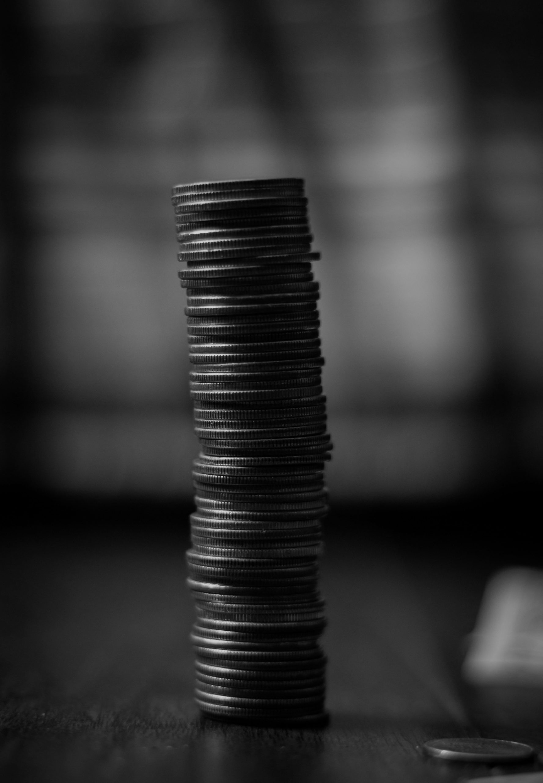 Black-and-white photograph of stacked coins representing the PR and GEO budget a growth-stage tech company may invest in communications and AI visibility.
