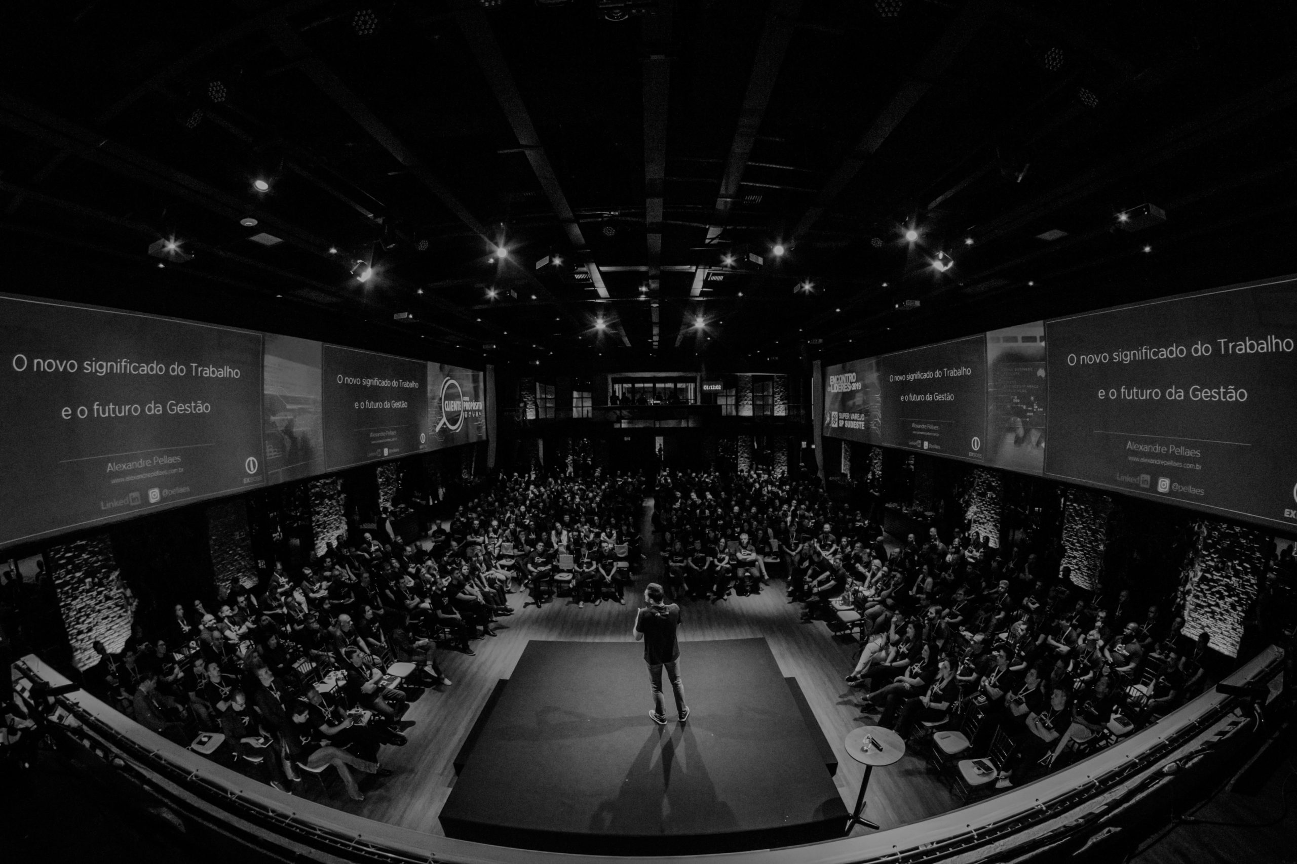 Black-and-white image of an executive speaking to a large audience, representing growth-stage PR, executive authority and category leadership after Series A.